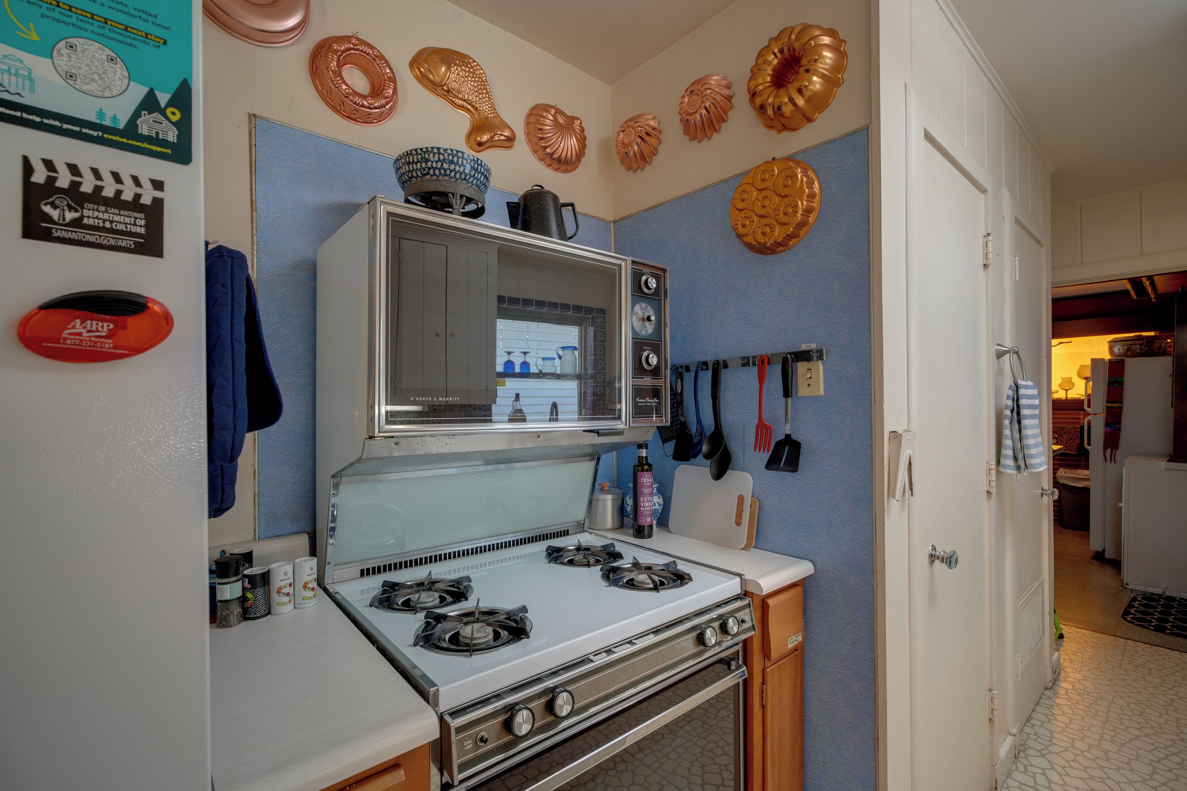 Una cocina equipada con estufa, microondas y diferentes utensilios.