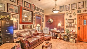 A cozy living room with a leather sofa, a vintage radio, and a fireplace. - San Antonio Rental w/ Courtyard: Walk to Riverwalk (San Antonio)