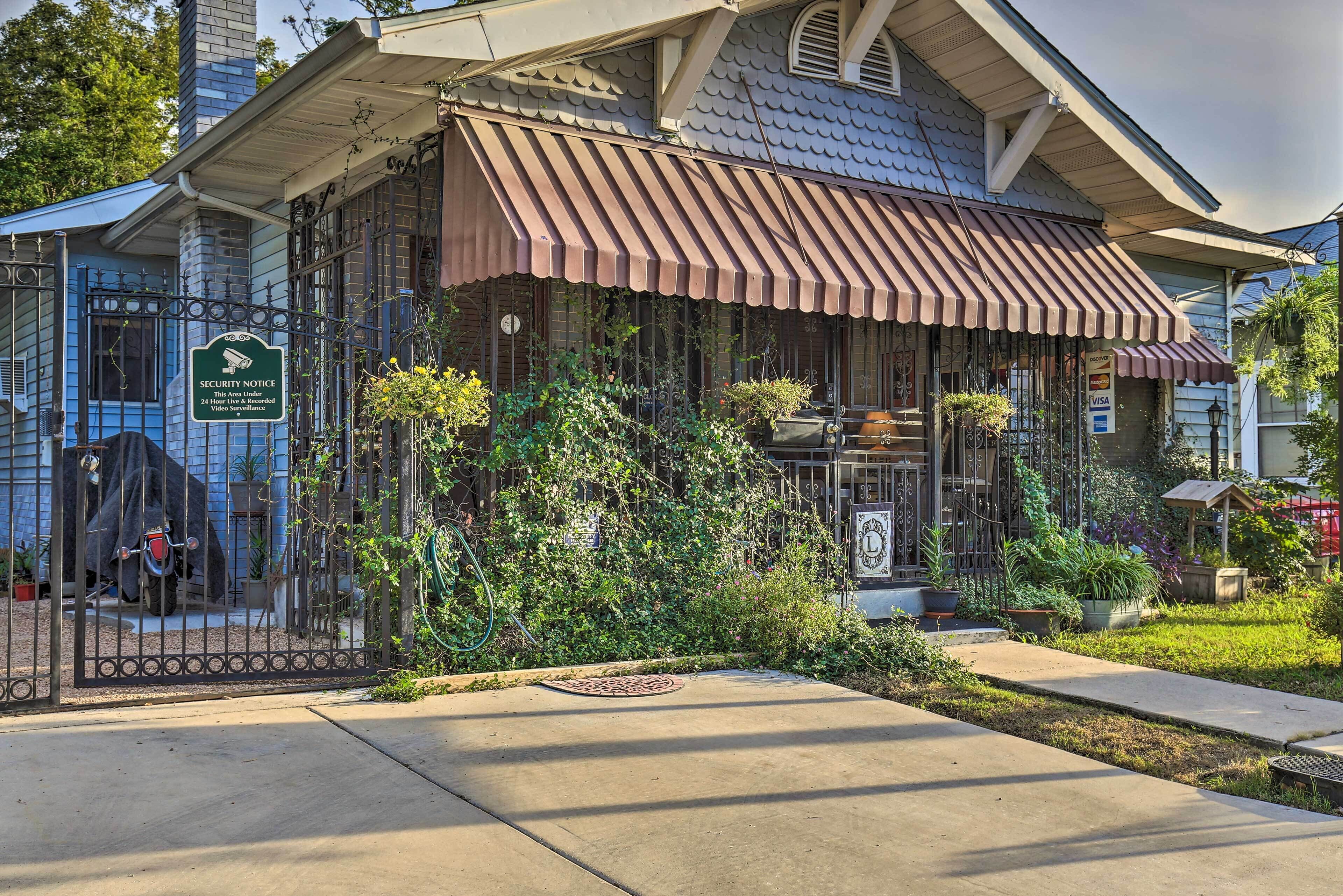 A building with a security notice sign, a covered patio, and a gated entrance.
