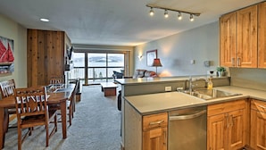 A spacious kitchen with wooden cabinets, a large island with a sink, and a dining area with a table and chairs. - Mtn-view Condo w/ Hot Tub Access in Dillon! (Dillon)