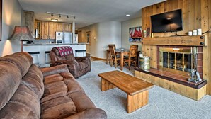 A cozy living room with a large brown leather sofa, a wooden coffee table, and a fireplace. - Mtn-view Condo w/ Hot Tub Access in Dillon! (Dillon)