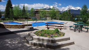 A pool area with two hot tubs, picnic tables, and a flower bed. - Mtn-view Condo w/ Hot Tub Access in Dillon! (Dillon)
