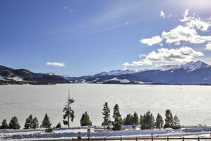 A panoramic view of a snow-covered lake with mountains in the background.