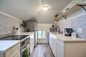 A modern kitchen with a central island, built-in appliances, and a window providing natural light. - Dtwn Golden Apt < 9 Mi to Red Rocks Amphitheater! (Golden)