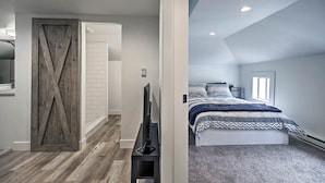A bedroom with a bed, a TV, and a wooden door. - Dtwn Golden Apt < 9 Mi to Red Rocks Amphitheater! (Golden)