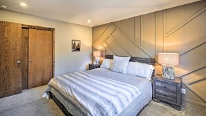 Ein Schlafzimmer mit Bett, Nachttischen, einem Holzschrank und einer Wandlampe.