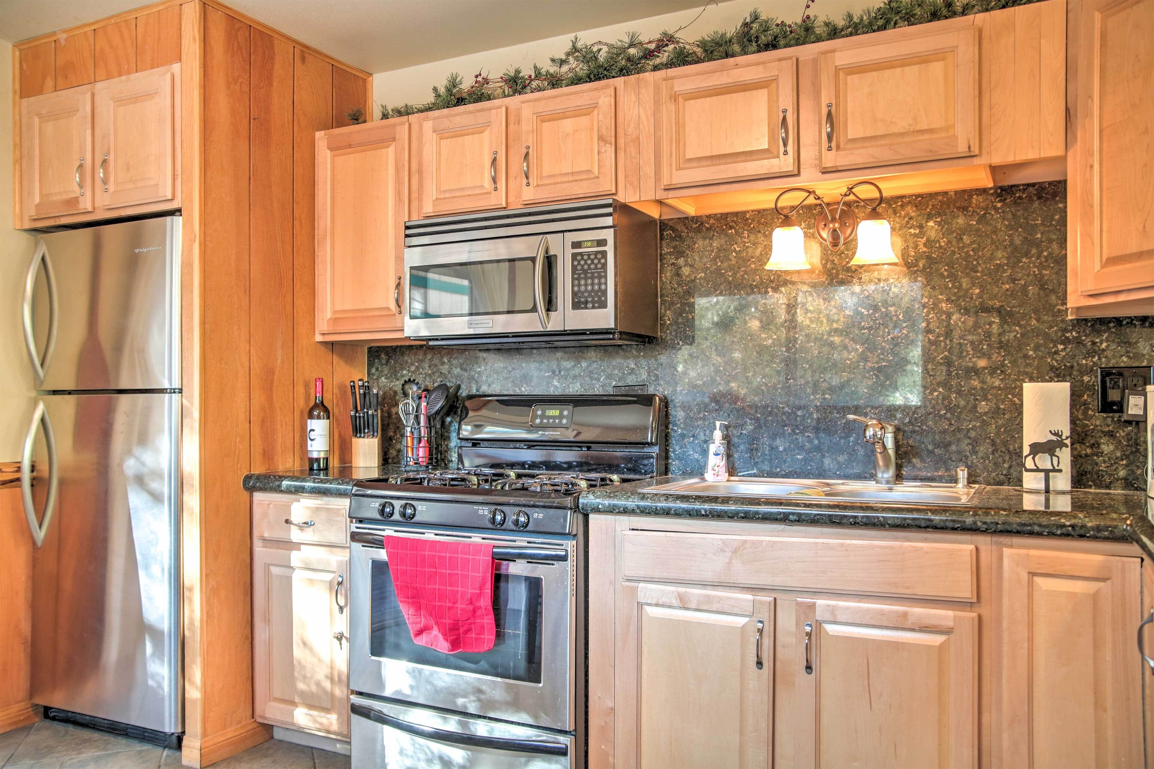 A kitchen with wooden cabinets, stainless steel appliances, a granite countertop, and a backsplash.