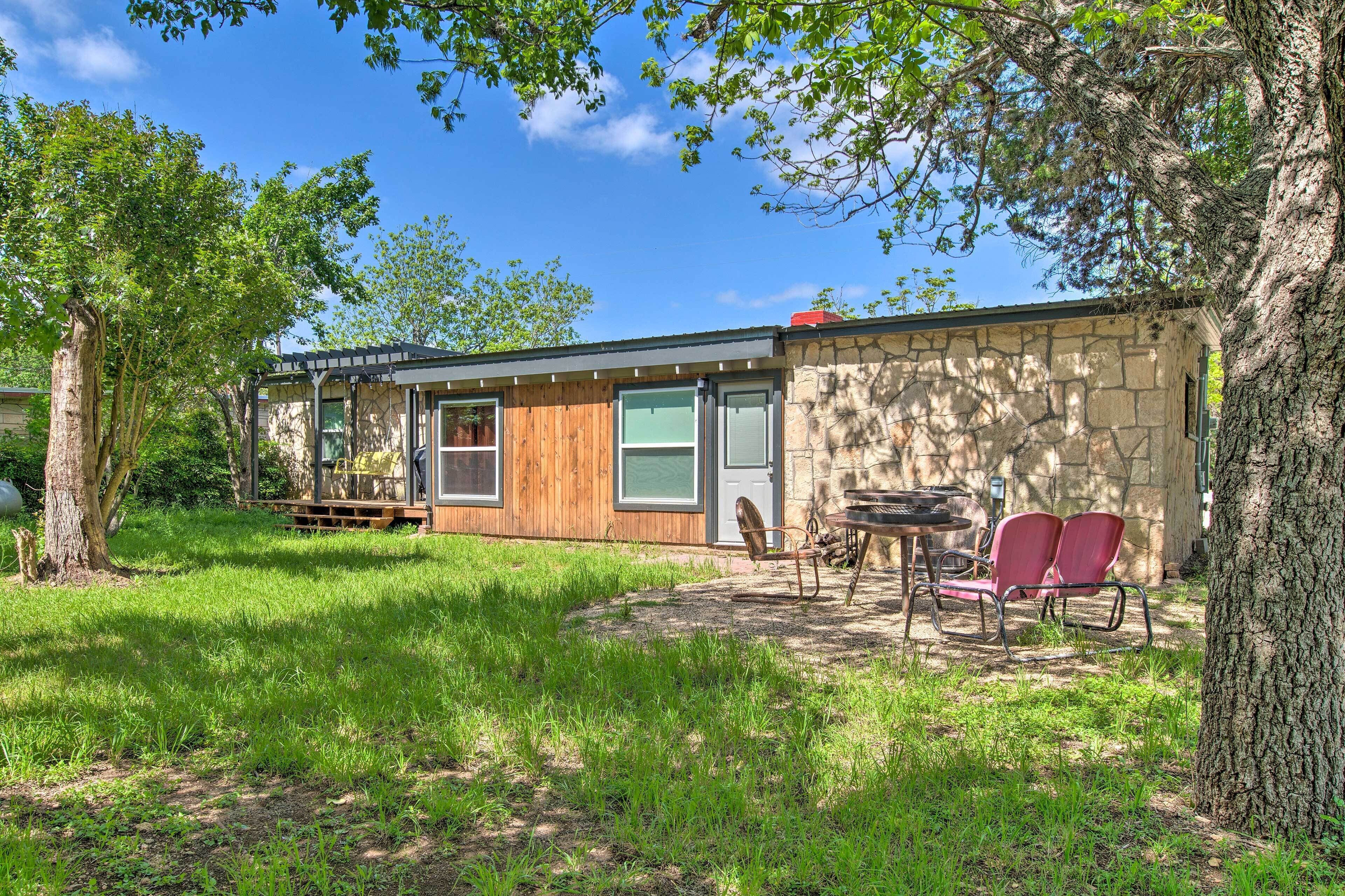 A rustic stone building with a wooden deck and outdoor seating.