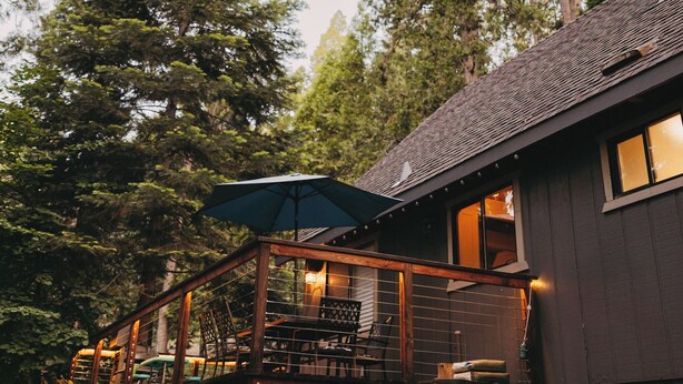 A wooden deck with outdoor seating and a large umbrella.