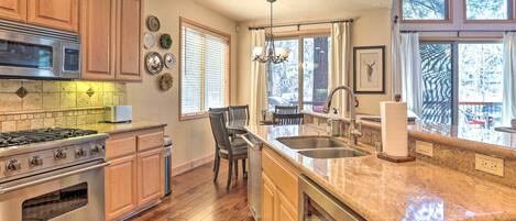 A kitchen with wooden cabinets, a stainless steel stove, and a granite countertop.