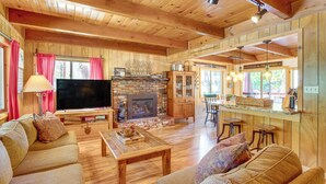 A cozy cabin interior with a living room, fireplace, wooden floors, and a kitchen area. - 10 Mi to Ski Slopes: South Lake Tahoe Home (South Lake Tahoe)