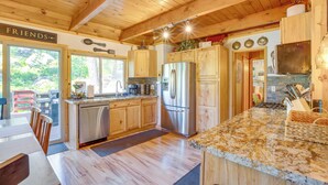 A wooden cabin kitchen with a granite countertop, stainless steel appliances, and a dining area with a table and chairs. - 10 Mi to Ski Slopes: South Lake Tahoe Home (South Lake Tahoe)