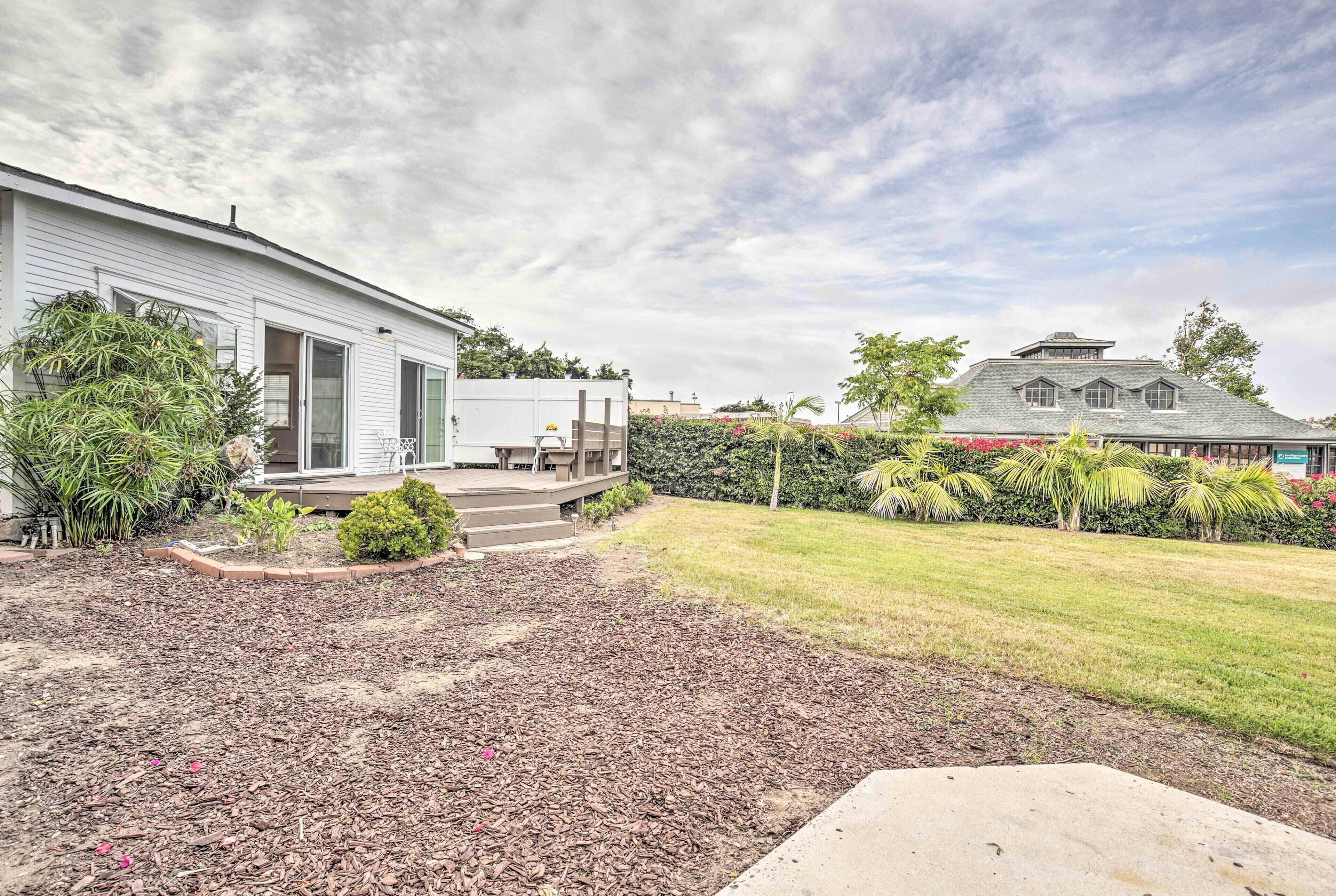 A residential property with a covered patio, a lawn, and a driveway.
