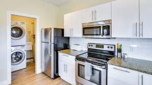 A compact kitchen with a stainless steel refrigerator, microwave, oven, and built-in washing machine. - Downtown Buena Vista Condo: Steps From Everything! (Buena Vista)