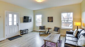 A living room with a sofa, two chairs, a coffee table, a TV, and a door. - Downtown Buena Vista Condo: Steps From Everything! (Buena Vista)