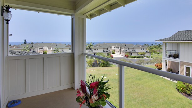 Ein Balkon mit Blick auf das Meer und angrenzende Häuser.