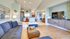 A spacious living room with a gray sofa, a glass coffee table, and a ceiling fan. - Luxe Maunalani Resort Condo w/ Pool + Beach Access (Kamuela)