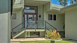 A modern house with a balcony, a staircase, and a small garden area. - Direct Oceanfront, Big Island Home (Keaau)