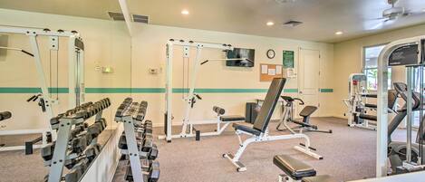 A gym with weight machines, benches, and a treadmill.