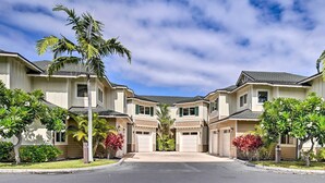 A residential street with two-story houses, each with a garage, surrounded by well-maintained lawns and palm trees. - Lanai & Resort-style Perks! Kona Townhome (Kailua-Kona)