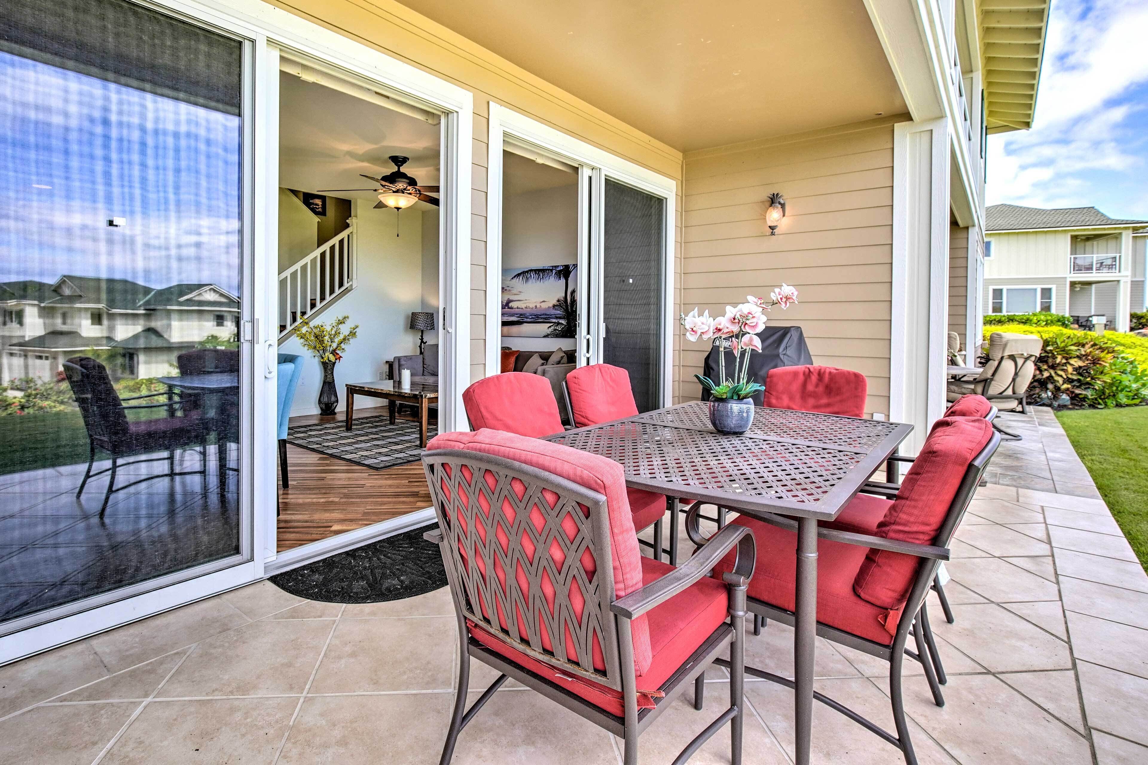 A patio with a table and chairs, a sliding glass door, and a view of neighboring houses.
