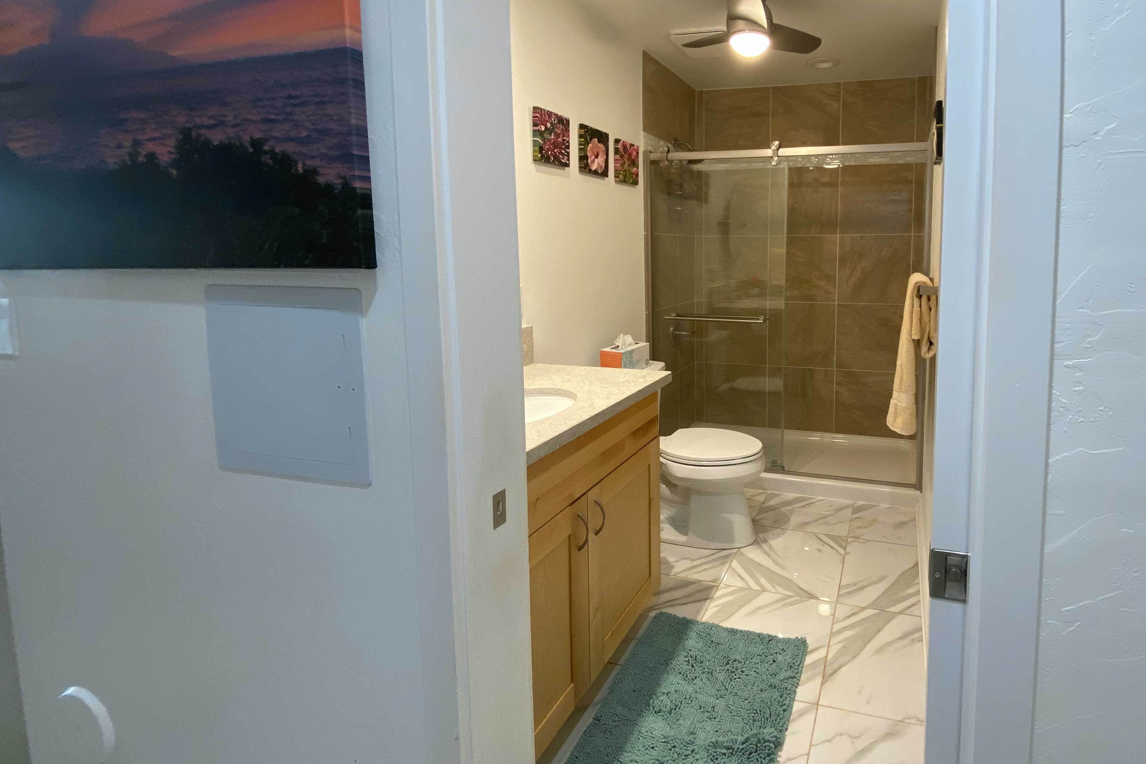 Un baño con ducha, inodoro y lavabo.