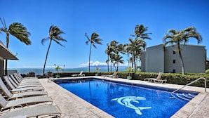 A swimming pool with lounge chairs and palm trees, overlooking the ocean. - High-end Resort Condo Nestled on Molokai Shoreline (Kaunakakai)