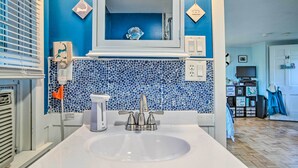 A bathroom with a blue mosaic tile backsplash, a white sink, and a mirror above it. - Romantic Cape Cod Studio w/ Patio, Near Beaches (Dennis Port)