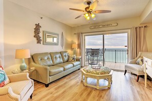 A living room with a sofa, armchairs, a coffee table, and a ceiling fan. - Beachfront Gulf Shores Condo w/ Pool (Gulf Shores)
