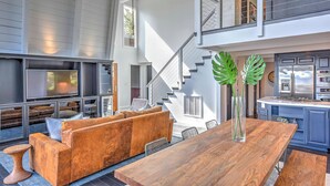 A spacious living area with a wooden dining table, a sofa set, and a kitchen with blue cabinets. - 10 Mi to Skiing: Tahoe City A-frame Home (Tahoe City)