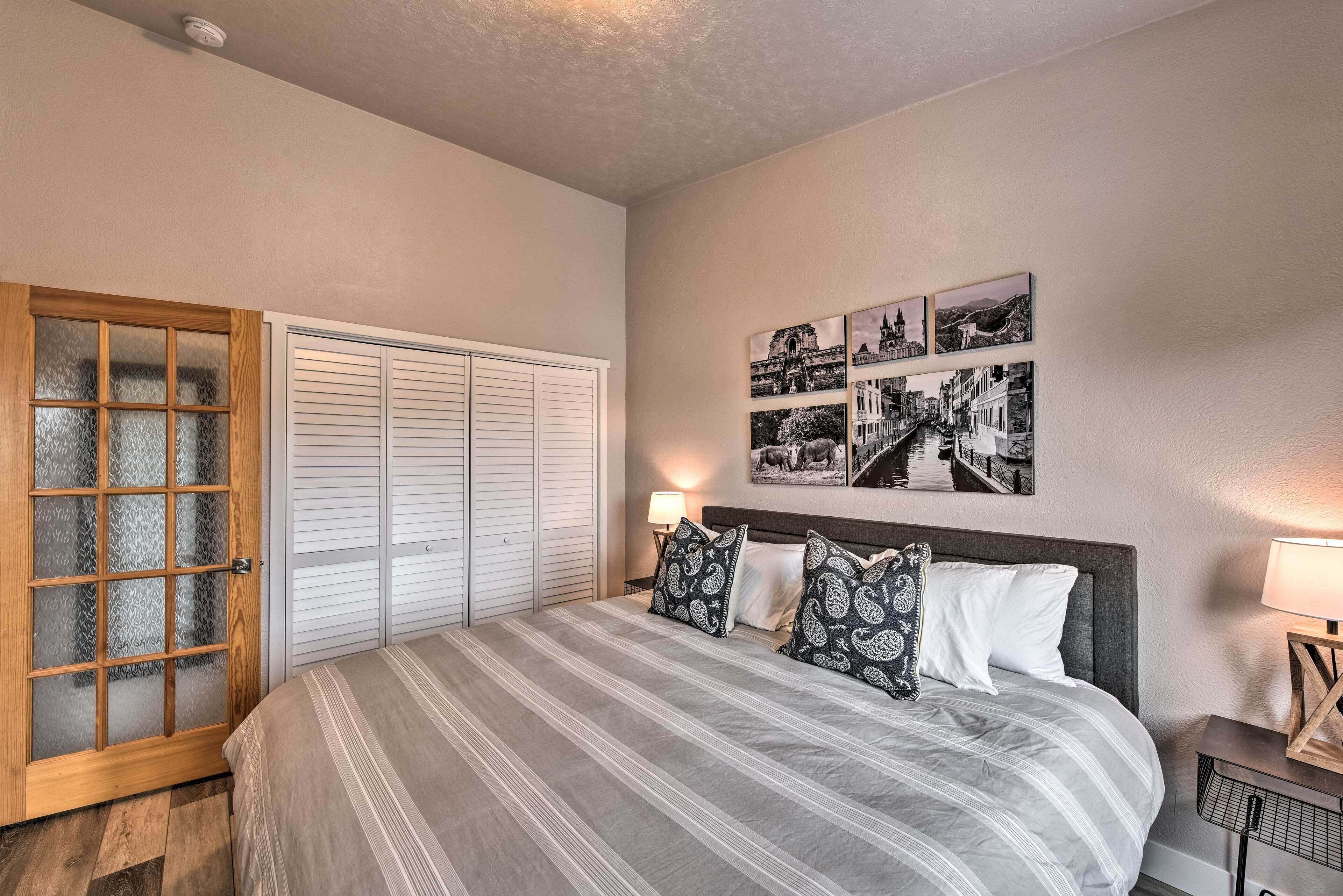 Un dormitorio con una cama grande, un armario con puertas correderas y una pared decorada con cuadros.