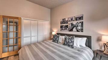 Un dormitorio con una cama grande, un armario con puertas correderas y una pared decorada con cuadros.
