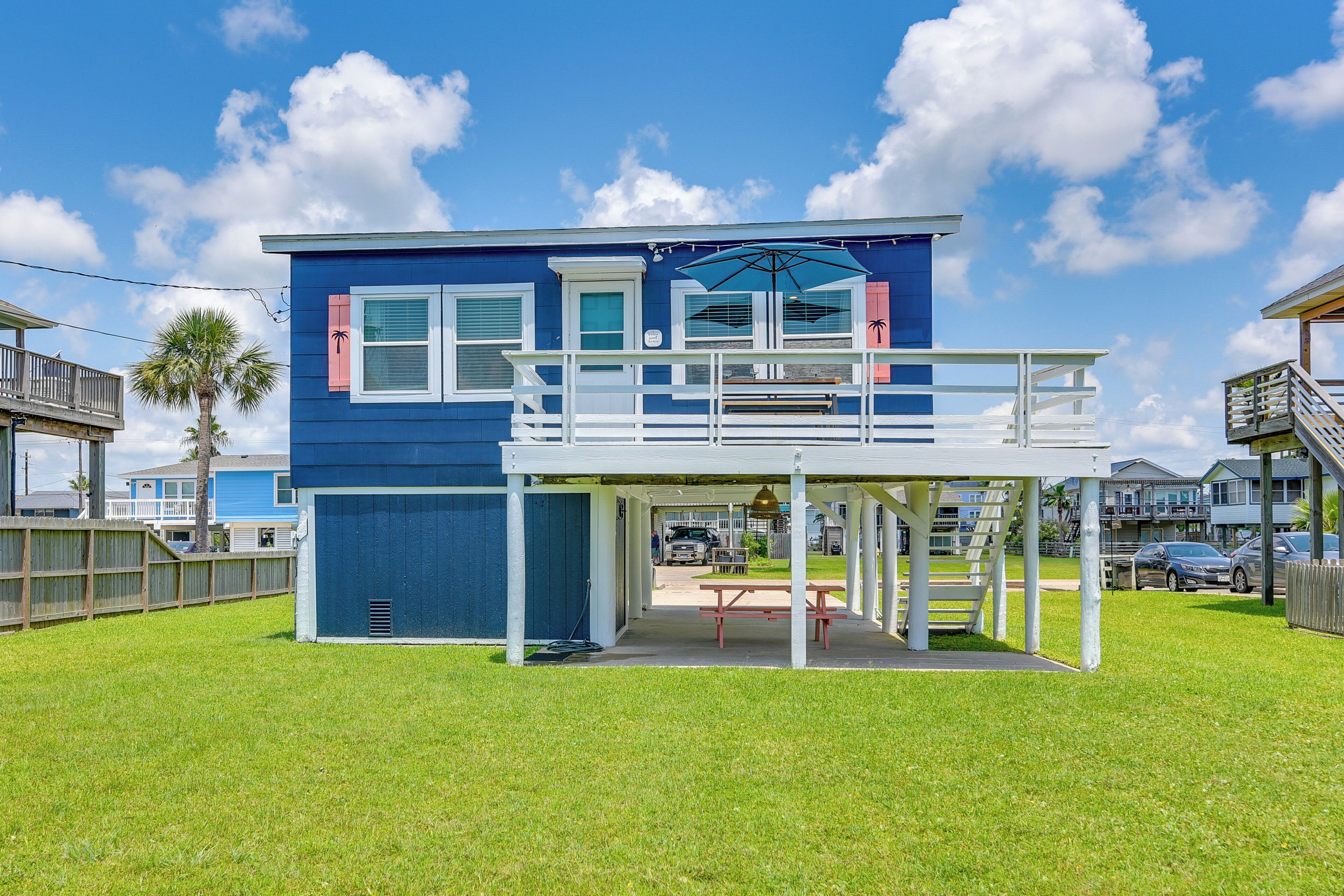 A two-story house with a balcony, a covered patio, and a front yard.