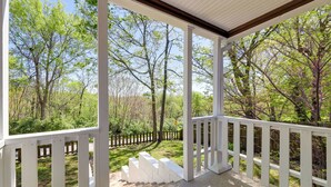 A covered porch with white railings and steps leading to a grassy area with trees. - Fayetteville Retreat w/ Yard - Walk to Campus! (Fayetteville)