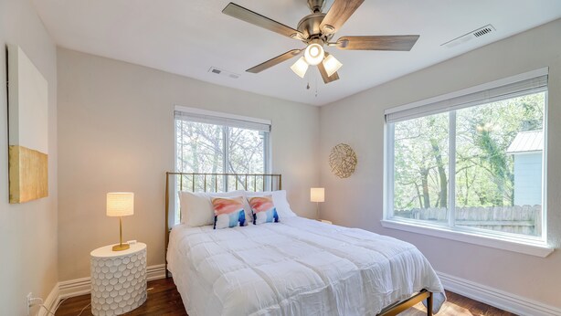 A bedroom with a bed, a ceiling fan, a window, and a nightstand. - Fayetteville Retreat w/ Yard - Walk to Campus! (Fayetteville)