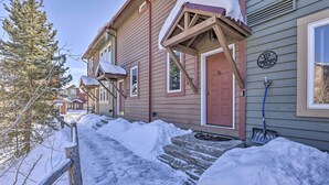 A residential building with a red door, a porch, and steps leading to the entrance. - Pet-friendly Fraser Condo w/ Community Hot Tub (Fraser)