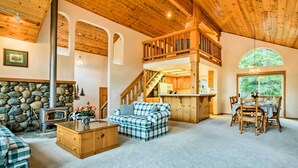 A cozy cabin interior with a stone fireplace, wooden furniture, and a dining area. - Hot Tub Access, Near Skiing: Tahoe Donner Cabin (Truckee)