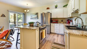 A kitchen with a central island, stainless steel appliances, white cabinets, and a red microwave. - Ski Getaway! Mtn-view Condo Near Keystone Resort (Dillon)