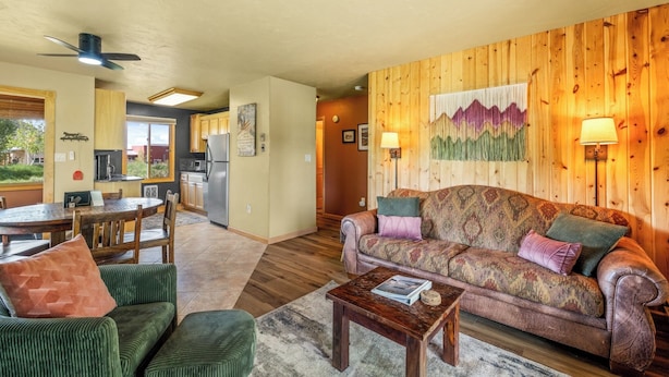 A cozy living room with a sofa, chairs, a coffee table, and a dining area with a table and chairs. - Knapsack- Newly updated mountain cabin! (Clark)