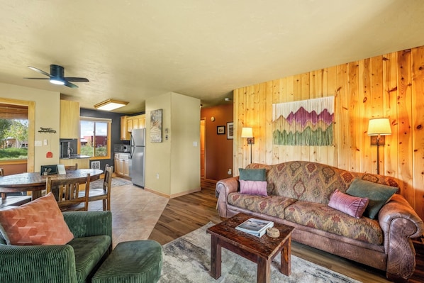 A cozy living room with a sofa, chairs, a coffee table, and a dining area with a table and chairs. - Knapsack- Newly updated mountain cabin! (Clark)