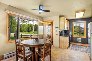A kitchen with a dining area, large windows, and a ceiling fan. - Knapsack- Newly updated mountain cabin! (Clark)