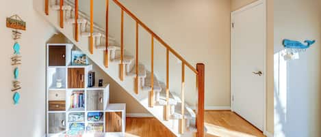 A staircase with wooden handrails and carpeted steps, leading to a door with a welcome sign.