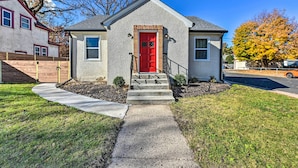 A single-story house with a red front door, a small front porch, and a concrete pathway leading to the entrance. - Mpls Duplex w/ Wifi & Kitchen: 5 Mi to Dtwn! (Minneapolis)