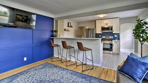 A modern kitchen with a central island, bar stools, and a blue accent wall. - Mpls Duplex w/ Wifi & Kitchen: 5 Mi to Dtwn! (Minneapolis)