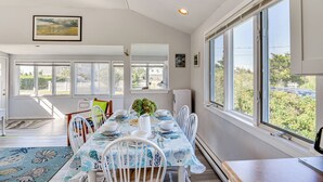 A dining area with a table set for four, large windows, and a view of the outdoors.