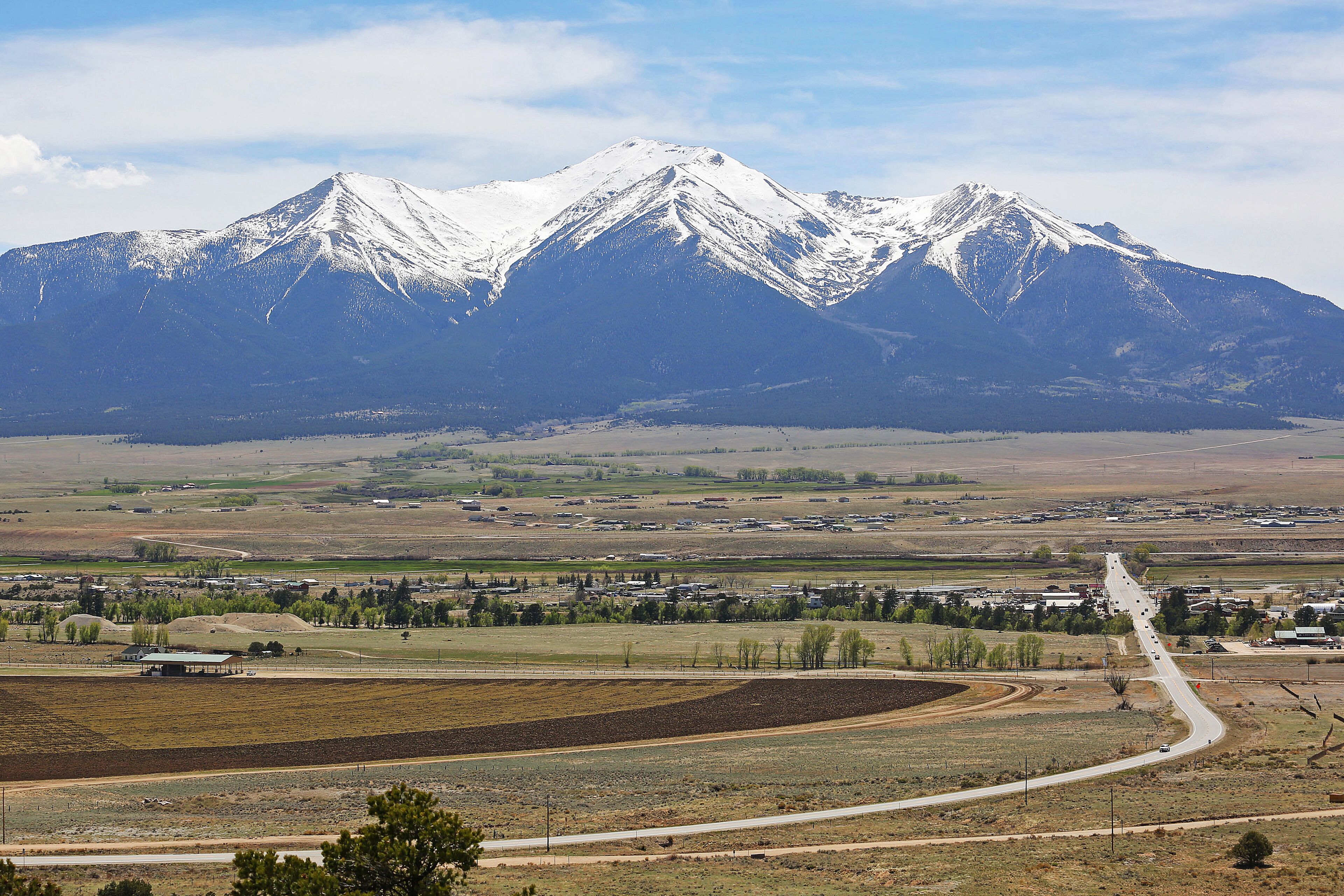 A mountainous landscape with a road leading to a small settlement.