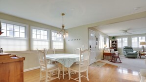 A spacious living room with a dining area, wooden flooring, and large windows. - Westerly Retreat ~ 1/4 Mi to Private Beach! (Westerly)