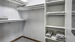 A closet with white shelves and a wooden floor. - Spacious Lakeside Family Home on Big Bearskin Lake (Harshaw)