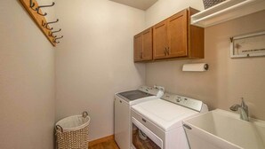 A laundry room with a washing machine, dryer, and a large sink. - Spacious Lakeside Family Home on Big Bearskin Lake (Harshaw)