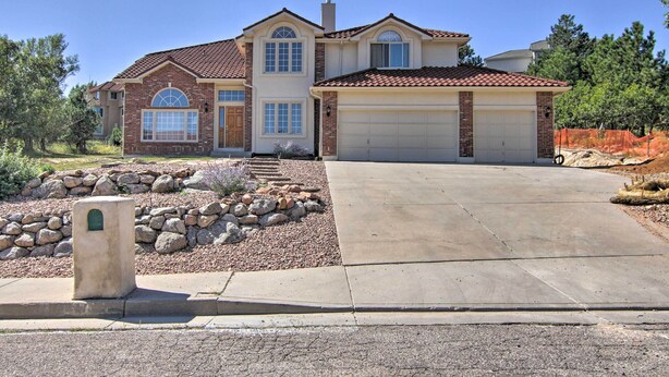 A two-story house with a garage, a stone pathway, and a landscaped garden with rocks and shrubs. - CO Springs Apartment < 6 Mi to Garden of the Gods! (Colorado Springs)